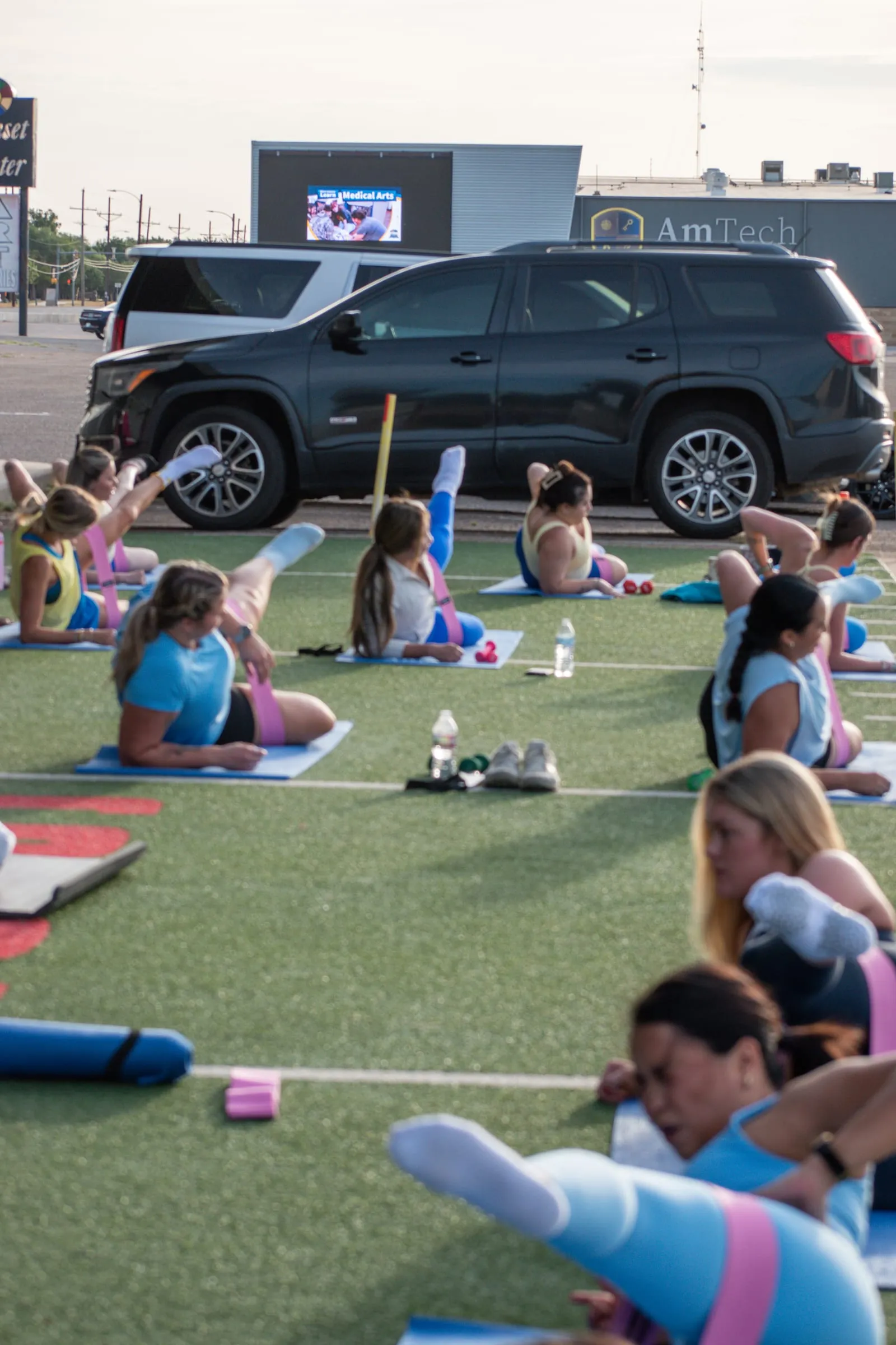 A large outdoor 806 Pilates class training together on the turf
